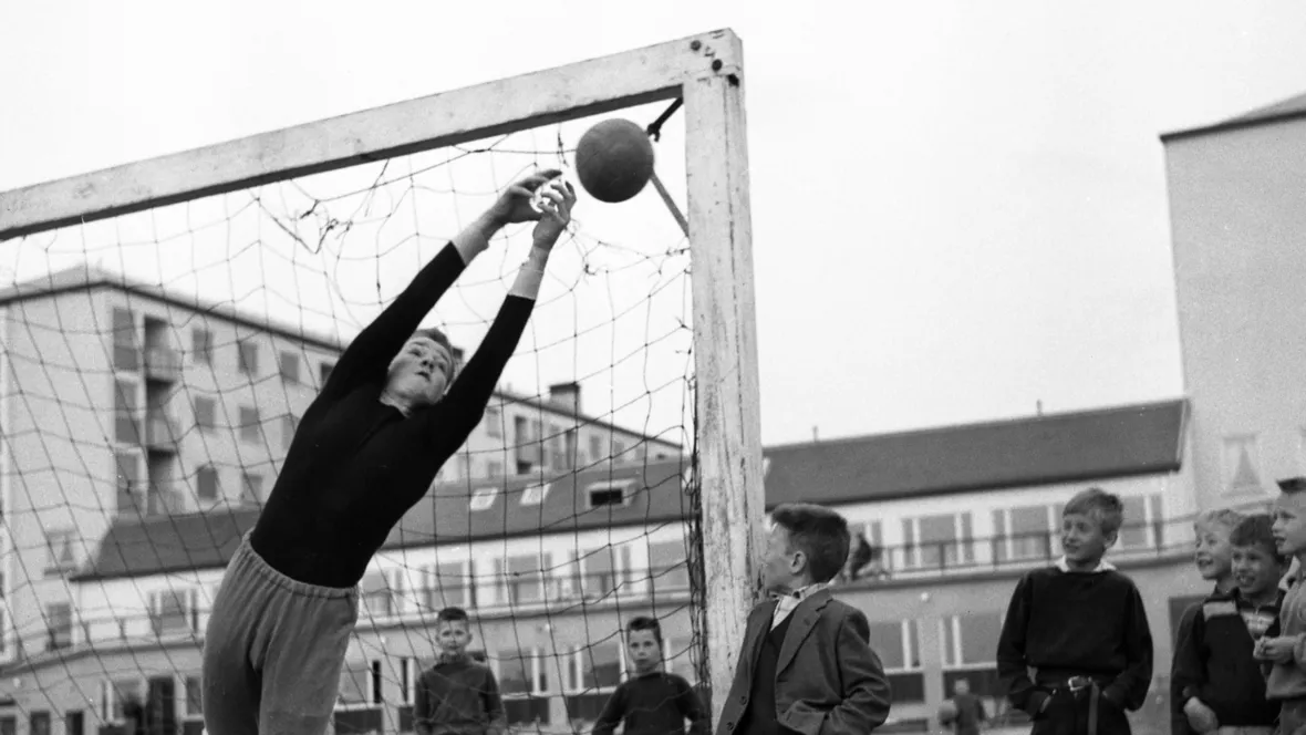 Svartvit bild pojkar som spelar fotboll.