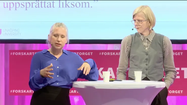 Två forskare talar under föreläsning