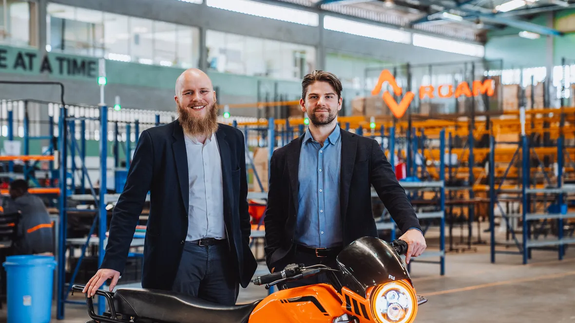 Två personer står i en fabrik.