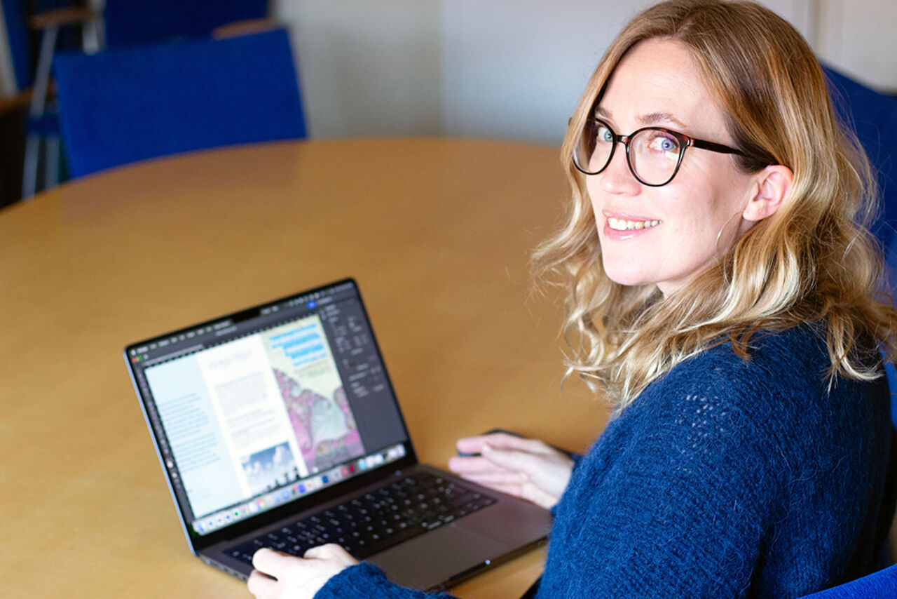 Porträtt av kvinna framför datorskärm