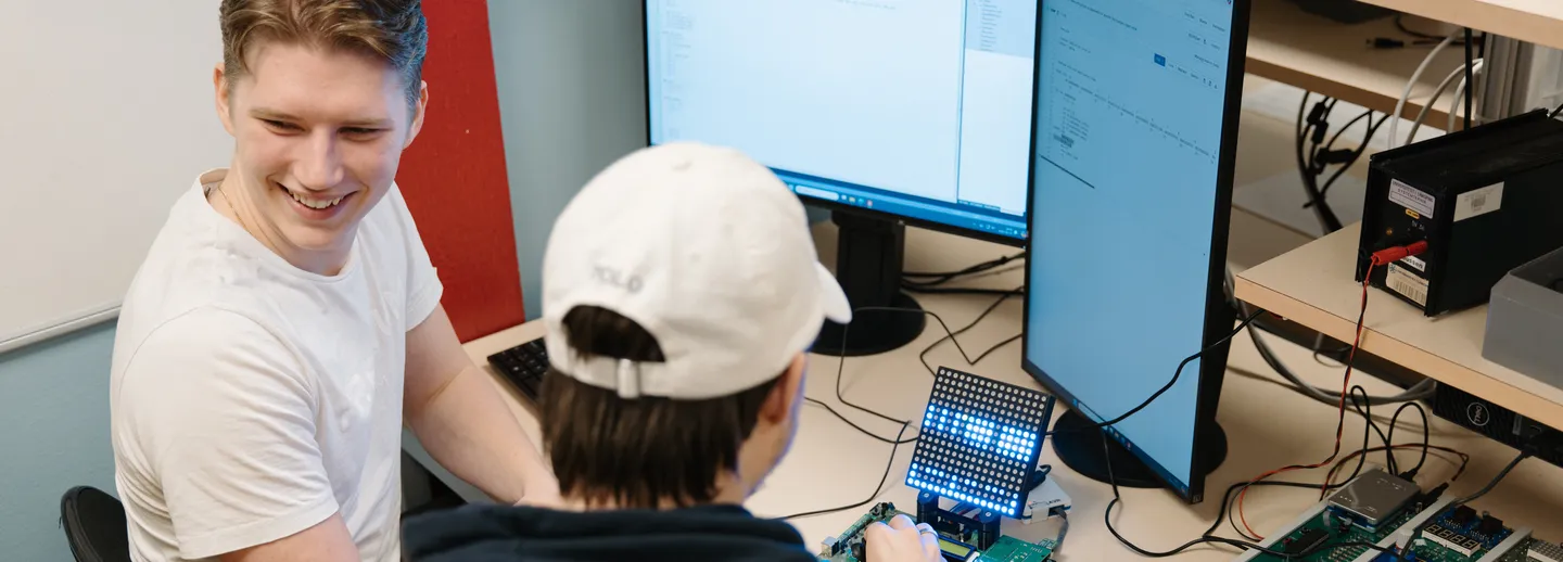 Två studenter programmerar elektronik.