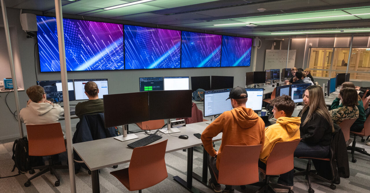 Computer room with students in front of computer screens.