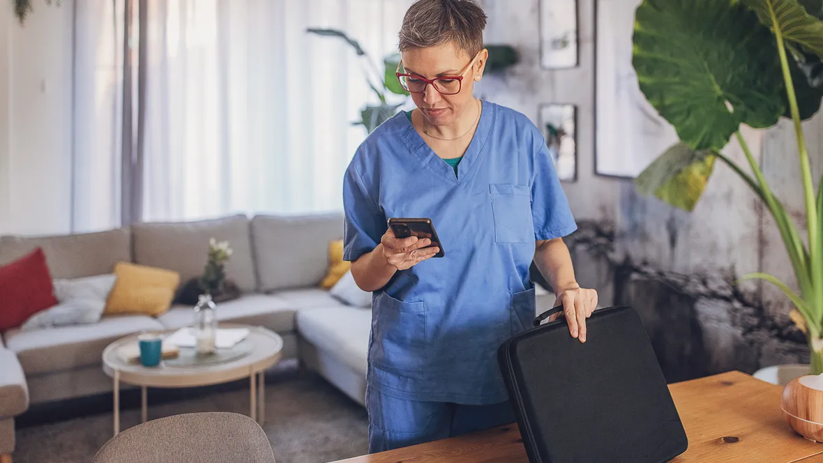 A nurse is looking at her mobilphone.