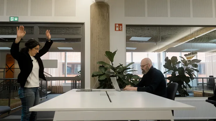 Kvinna som rör sig, man som sitter