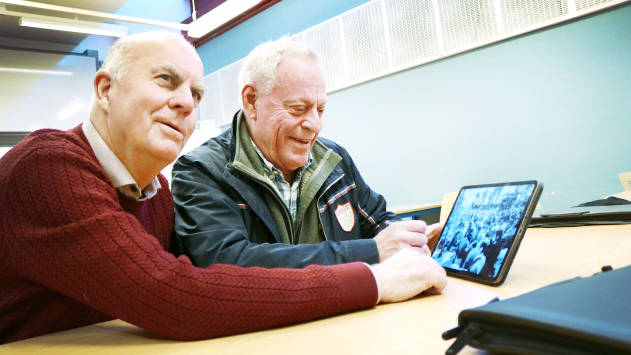 Två män tittar på bilder. 