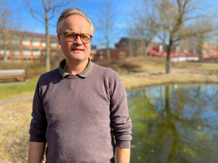 En man i halvbild tittar vid sidan av kameran.
