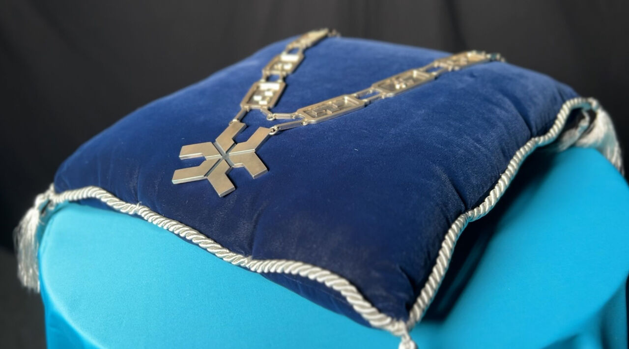 A Vice-Chancellor’s chain of silver lies on a pillow