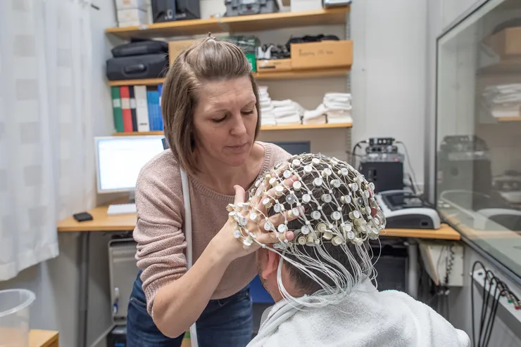 kvinnlig forskare med deltagare i EEG-labbet.