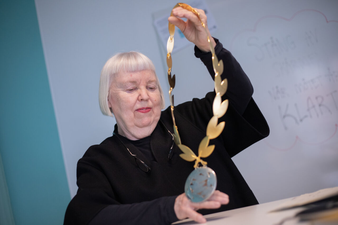 A woman is holding a Deans chain