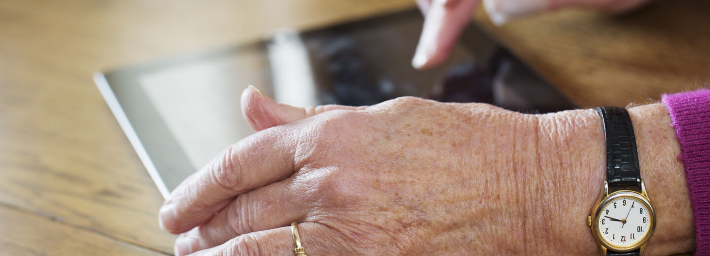 Äldre person använder en surfplatta