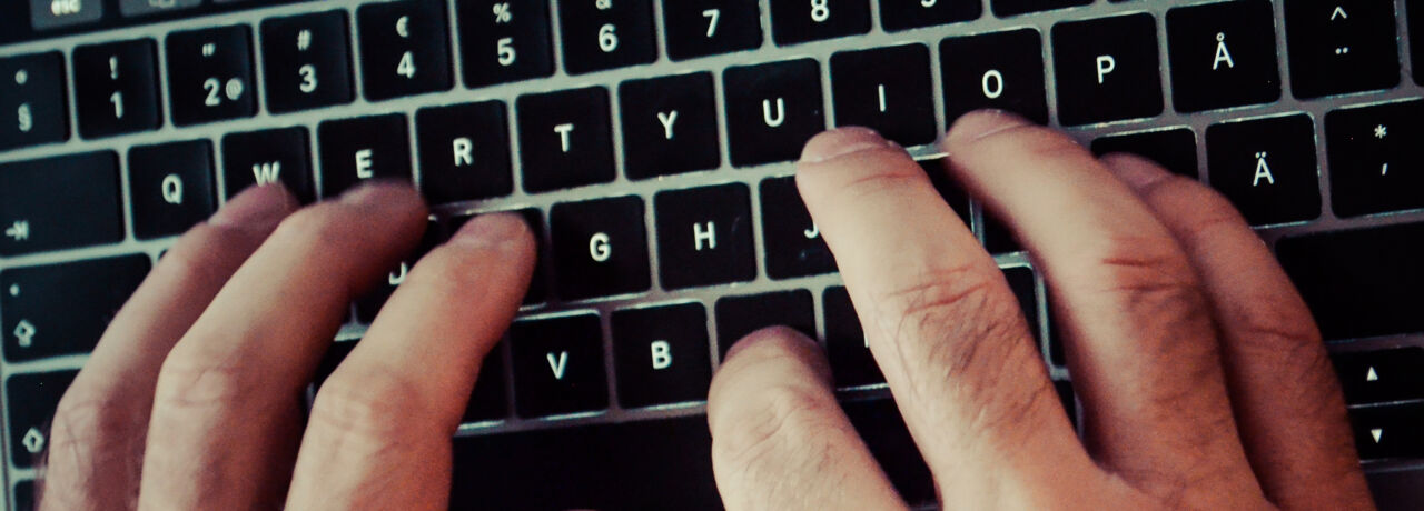 Hands writing on a laptop