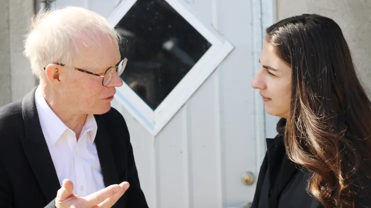 Man och kvinna samtalar vid föreläsning. Man a