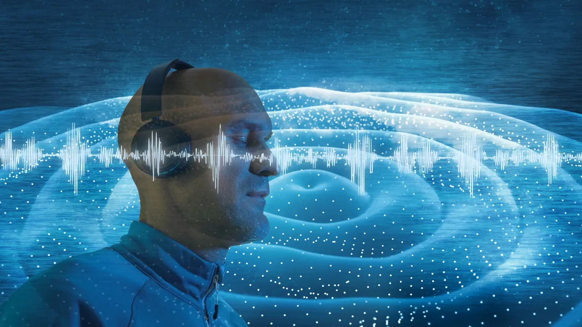 En man with headphones listens to music, all around him music waves are visible. 