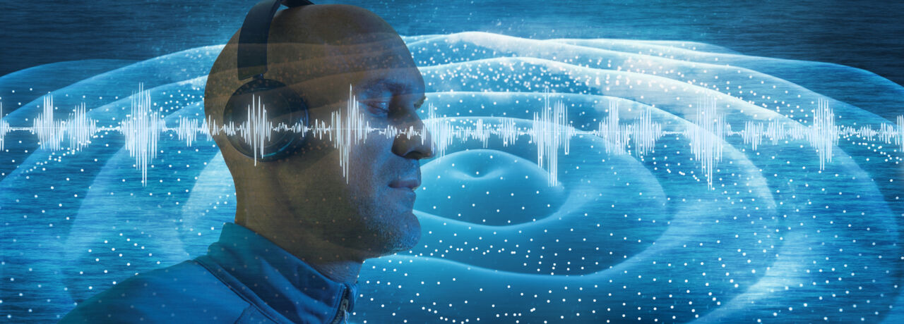 En man with headphones listens to music, all around him music waves are visible. 