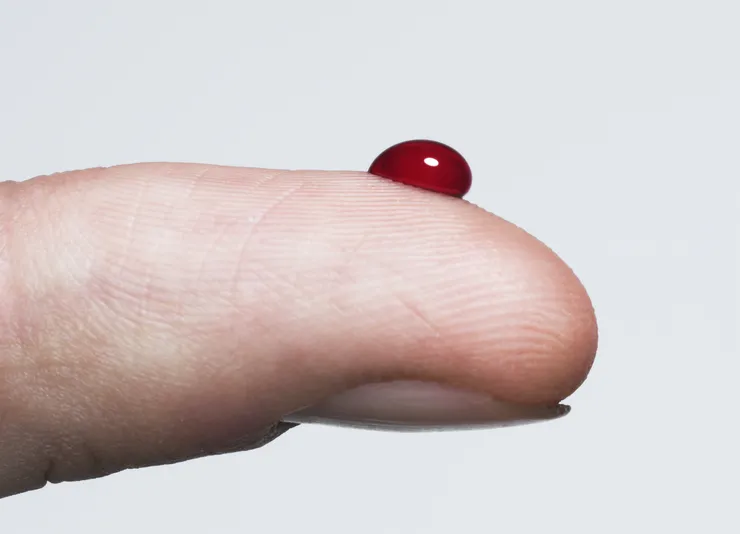 En droppe blod på ett finger