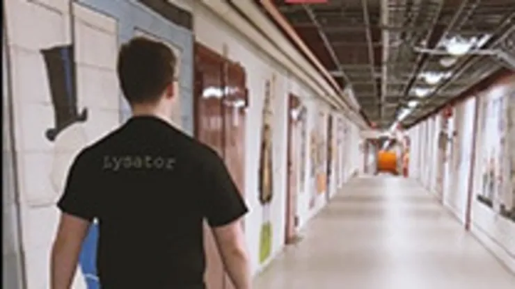 en student i svart t-shirt går i en korridor