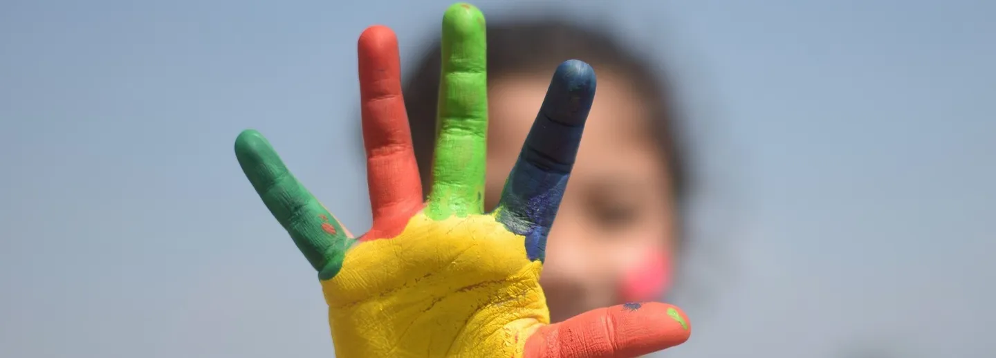En kvinna sträcker fram fem fingrar i olika färger.