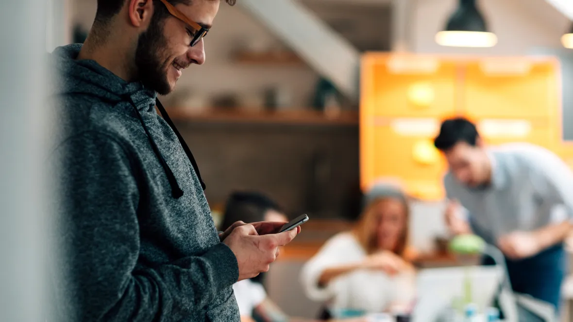 Student som tittar på sin mobil.