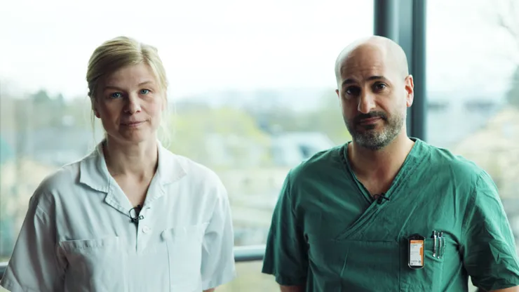 Personer står framför fönster iklädda läkarkläder.