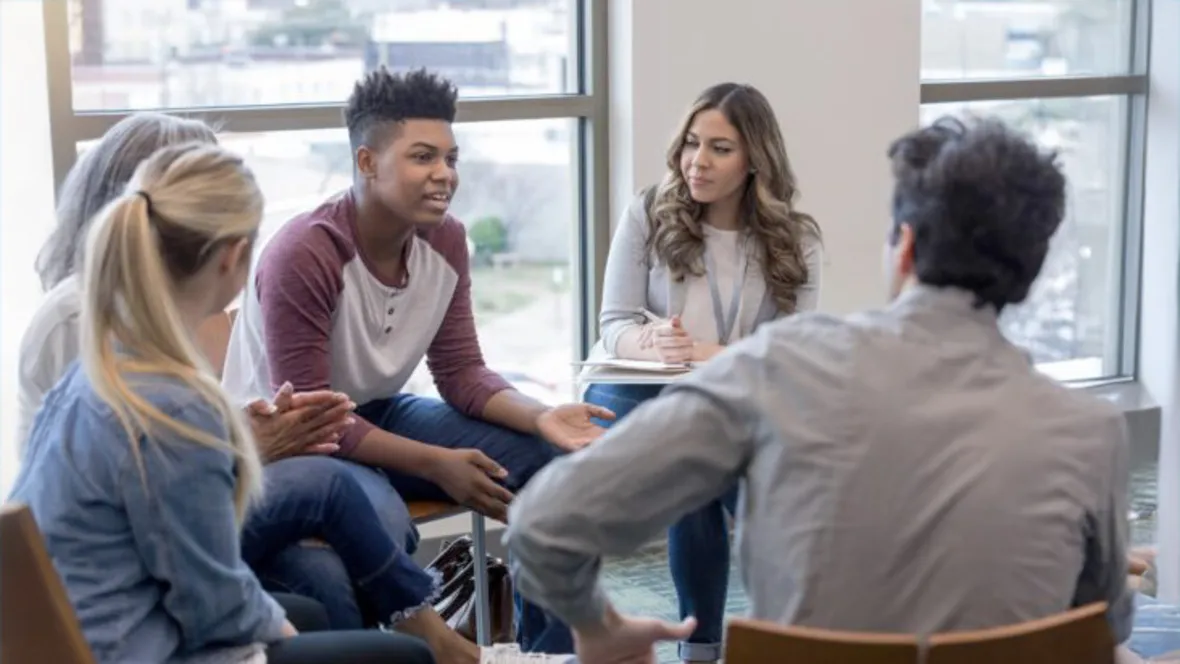 Personer sitter i grupp och diskuterar.