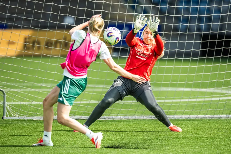 Kvinnlig målvakt räddar en boll