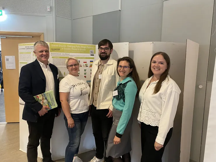 Five people in front of a poster