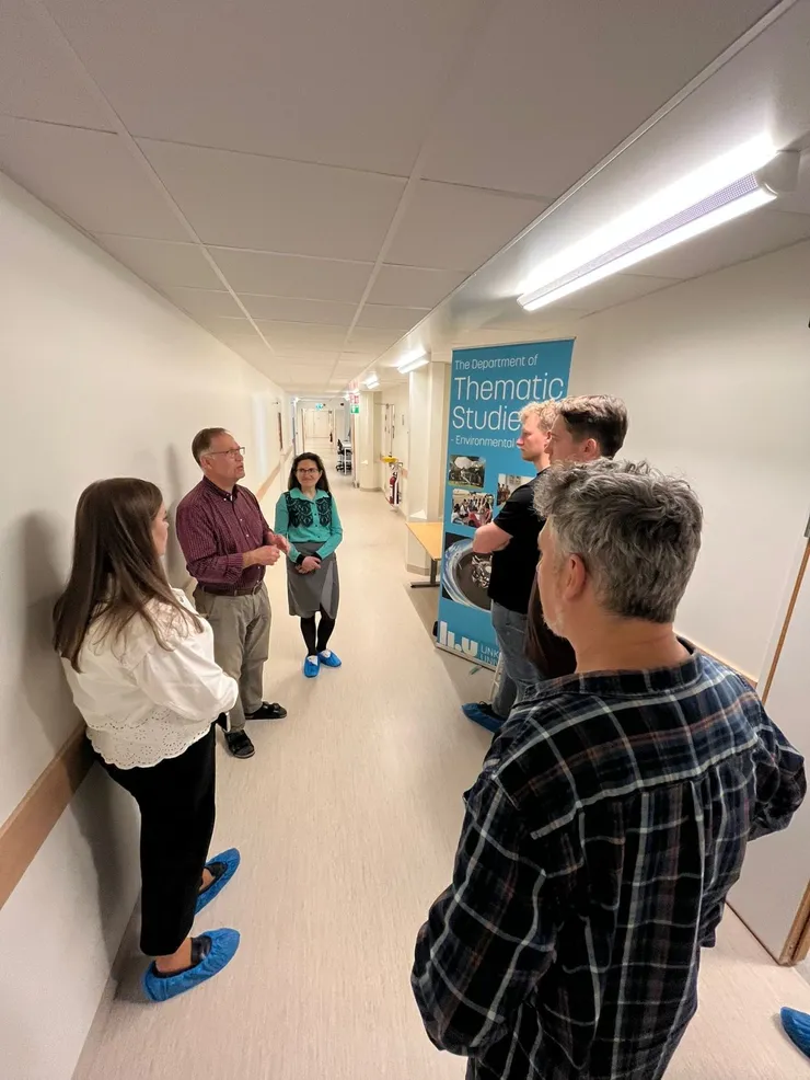 A group of people talking in a corridor