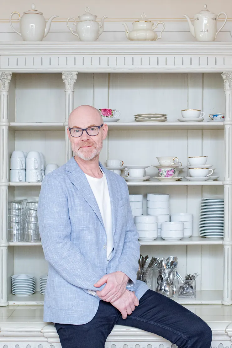 Forskaren Lars Jämterud framför en hylla med porslin.
