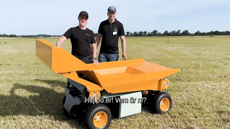 Två personer står framfören gul maskin.