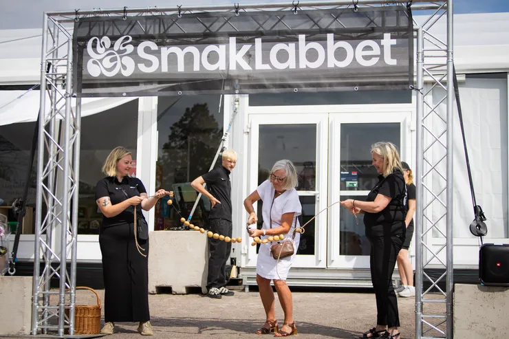 Invigningen av smaklabbet där bandet, bestående av potatis, klipps av kommunfullmäktiges ordförande framför arenan.