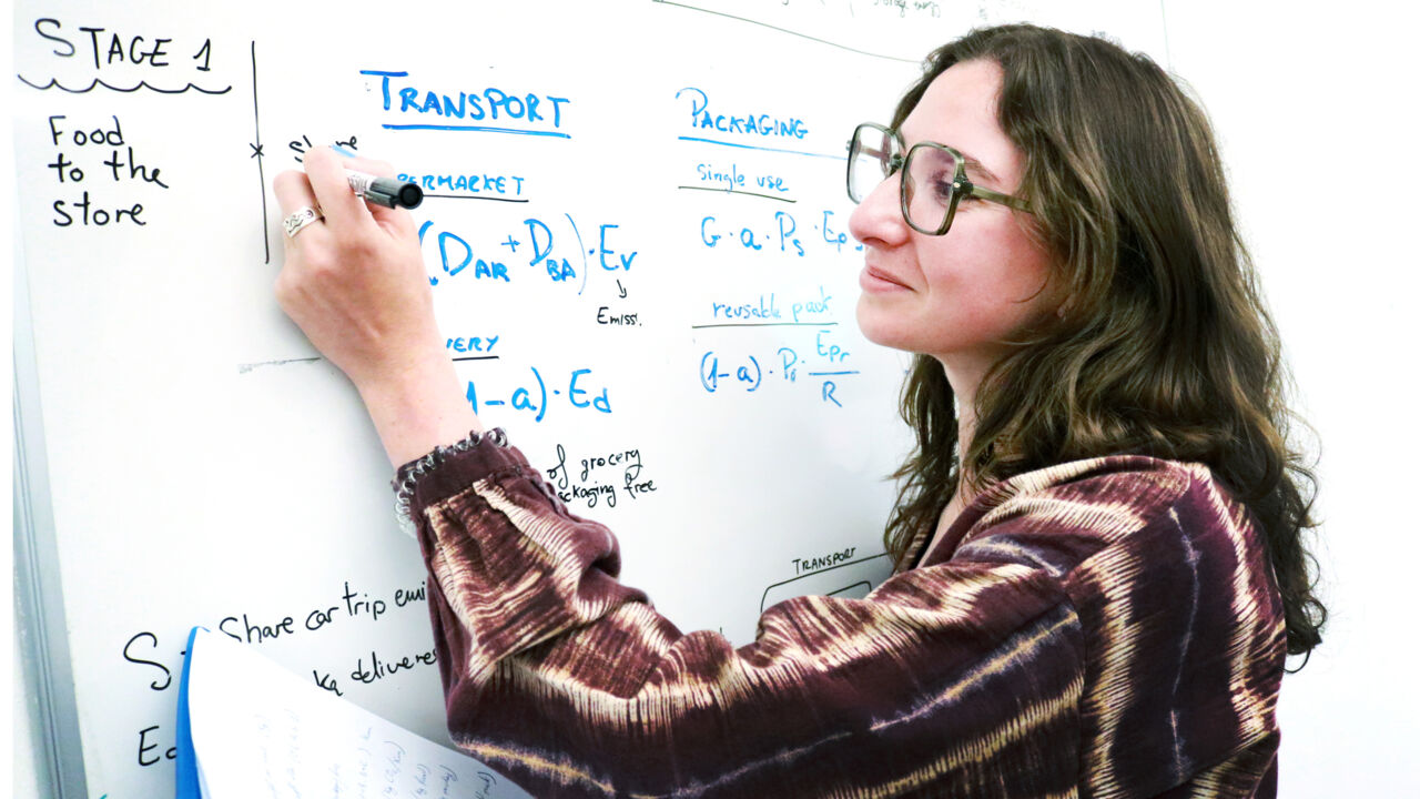 Kvinnlig doktorand, mörkt hår, glasögon.