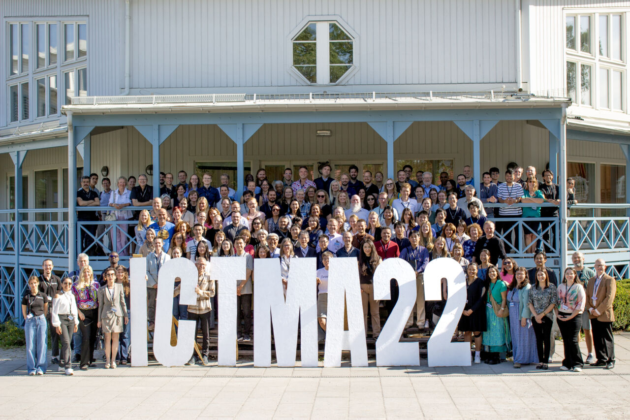 En stor grupp människor framför bokstäverna ICTMA22