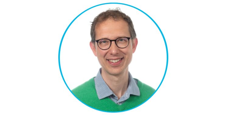 Ett porträtt av en man med glasögon och grön tröja