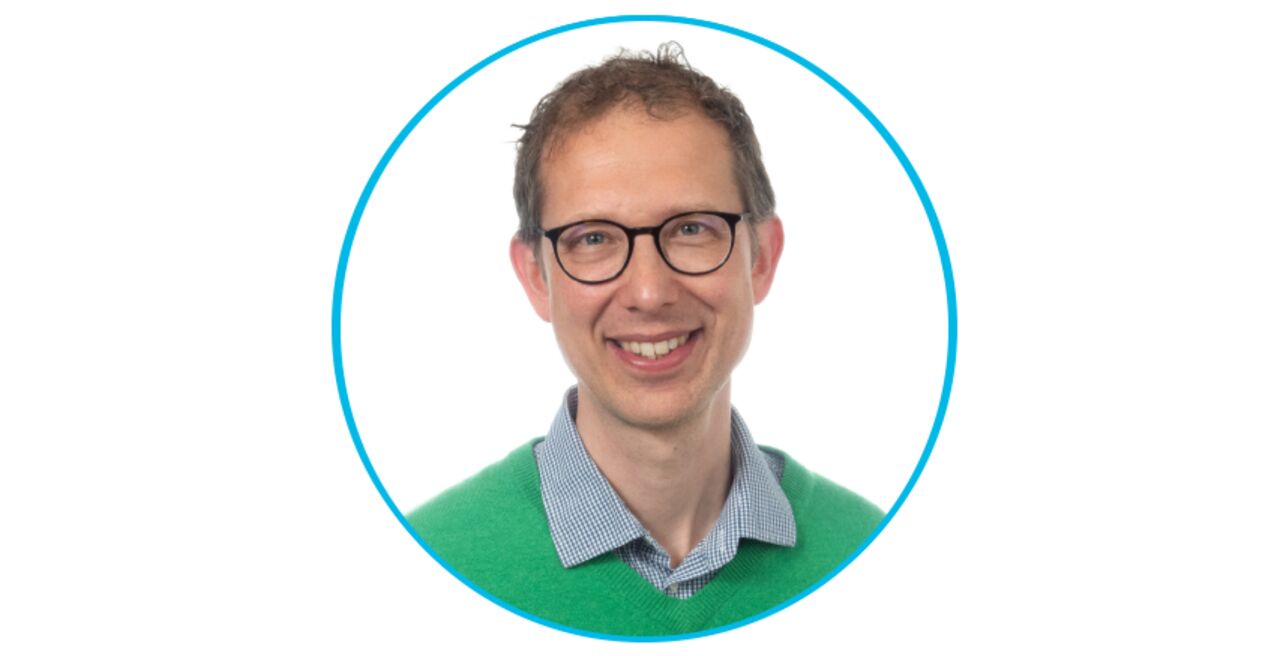 Ett porträtt av en man med glasögon och grön tröja