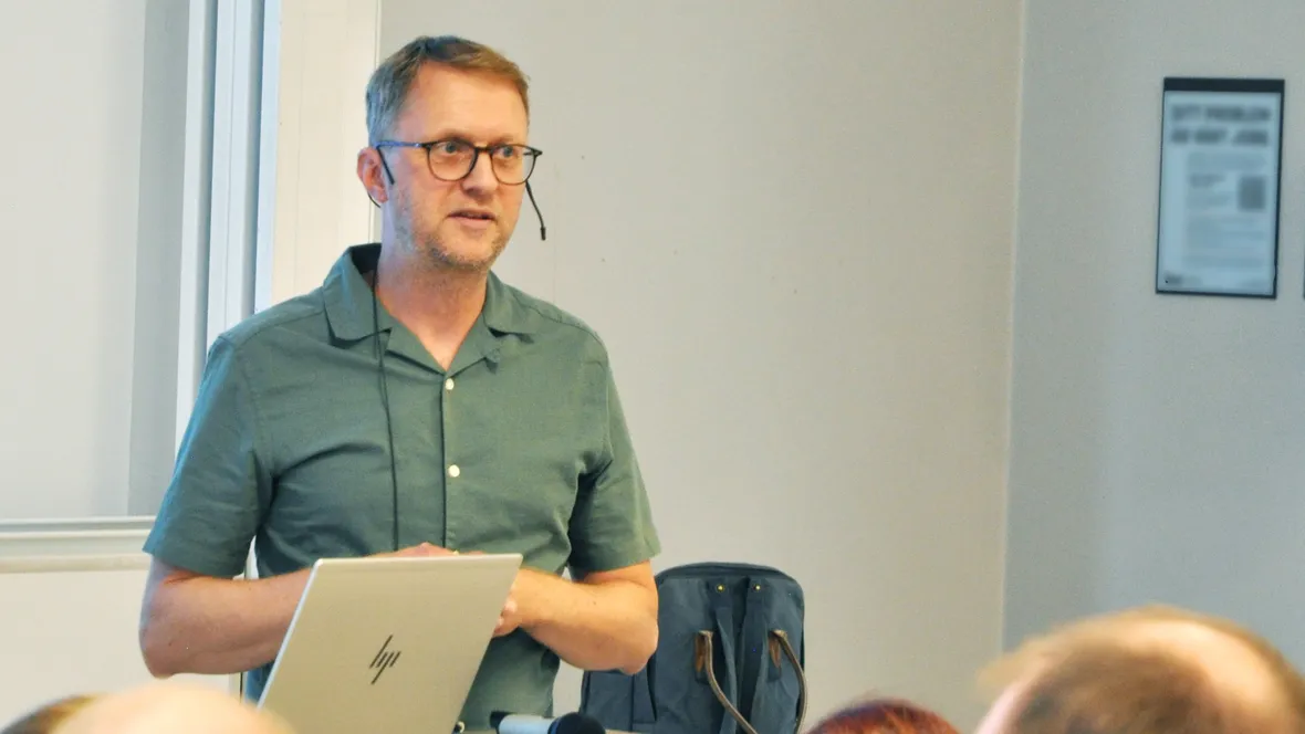 Man föreläser framför publik