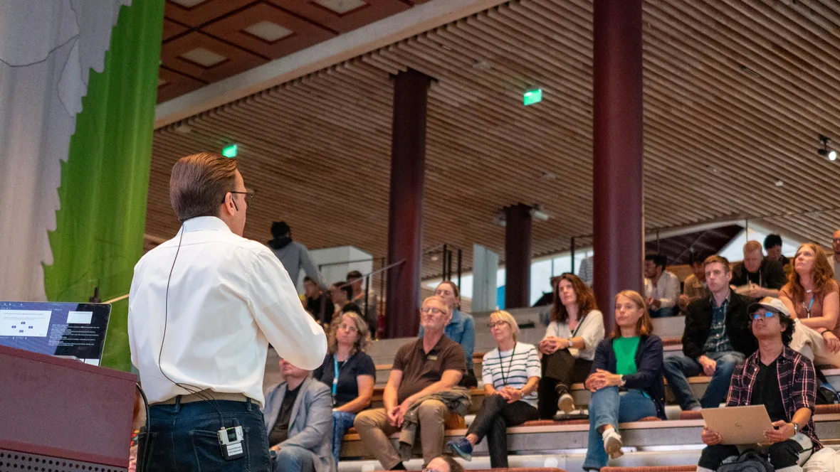 A man presenting to an audience, engaging the crowd with his speech and visual aids.
