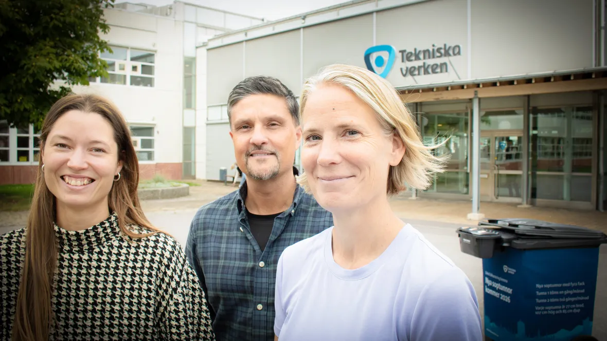 En man och två kvinnor utanför en byggnad.