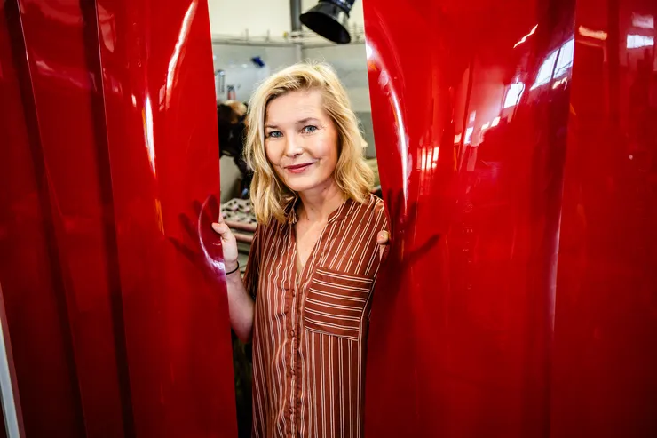 Person (Lisa Lundström) tittar fram mellan två svetsskynken.