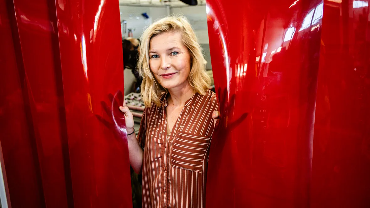 Person (Lisa Lundström) tittar fram mellan två svetsskynken.