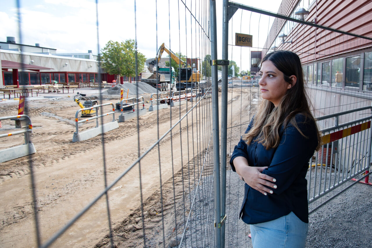 Pardis Niknafs står bredvid ett stängsel och tittar ut mot Corson som byggs om.