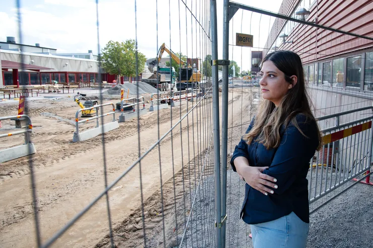 Pardis Niknafs står bredvid ett stängsel och tittar ut mot Corson som byggs om.