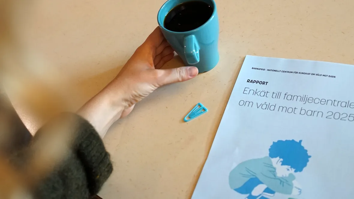 en rapport som ligger på ett bord tillsammans med en blå kaffekopp och ett blått gem