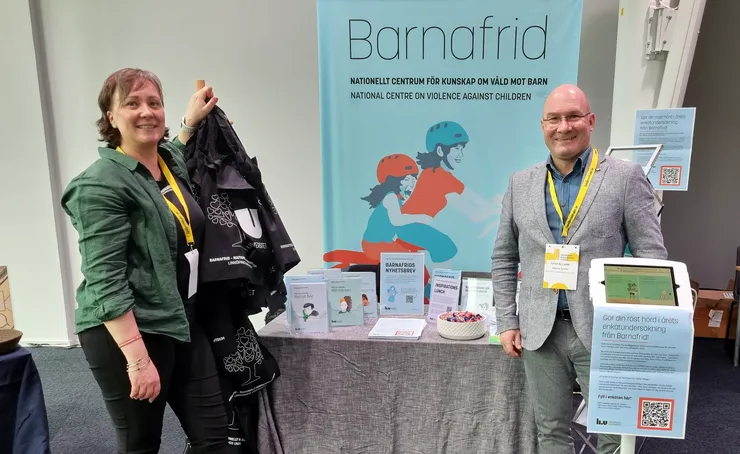 Två personer framför ett mässbord med material