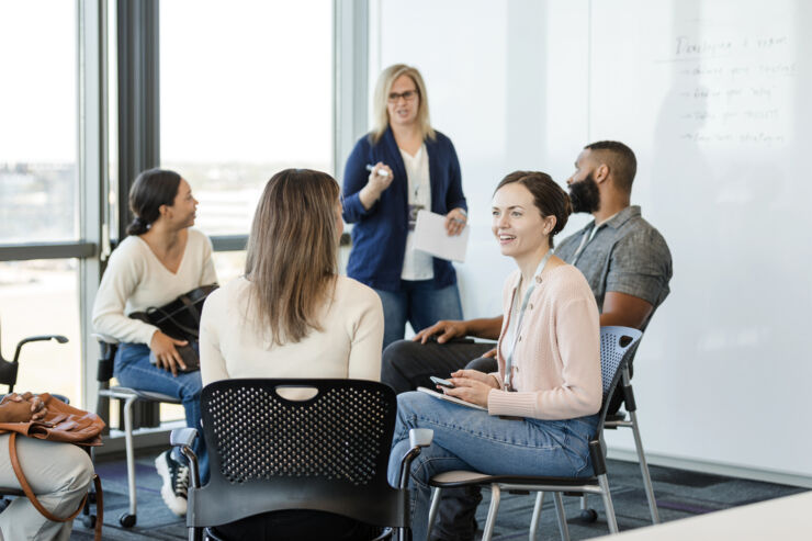En grupp människor sitter runt ett bord och diskuterar.