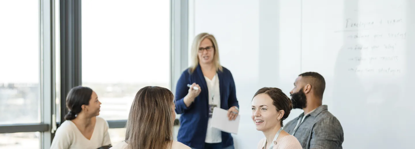 En grupp människor sitter runt ett bord och diskuterar.