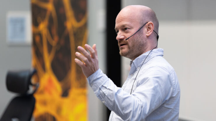 Man talking in front of an audience.