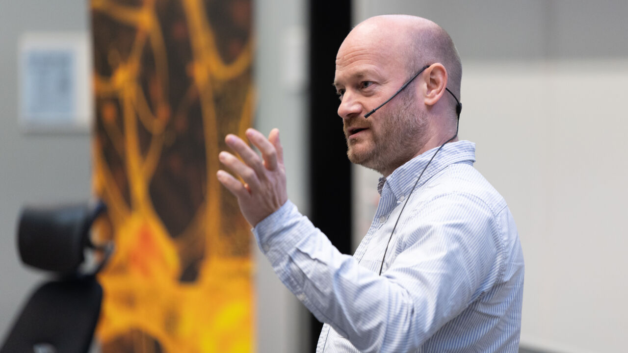 Man talking in front of an audience.