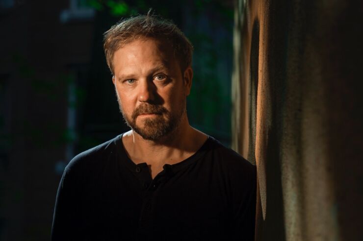 Foto av en man framför en mörk bakgrund