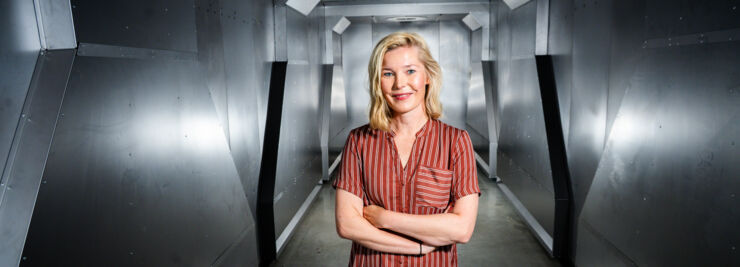 Person (Lisa Lundström) som står i ett rum med metallklädda väggar.