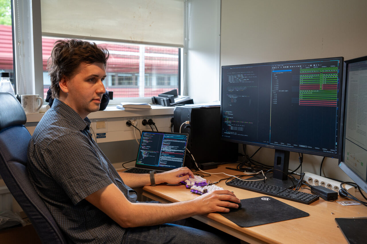 Frans Skarman sitter vid skrivbordet med datorskärmar framför sig.